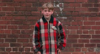 Movie still from “The Full Monty” (1997), directed by Peter Cattaneo – A boy in a red and black checkered jacket; Medium shot, High angle