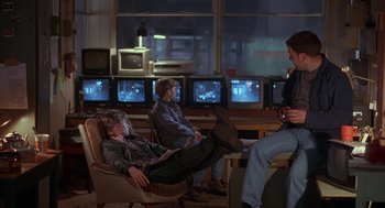 Movie still from “The Full Monty” (1997), directed by Peter Cattaneo – A group of people sitting in chairs in a room; Wide shot, Over the shoulder angle