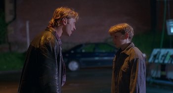 Movie still from “The Full Monty” (1997), directed by Peter Cattaneo – Two young men standing next to each other on the street; Medium shot, Over the shoulder angle