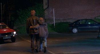 Movie still from “The Full Monty” (1997), directed by Peter Cattaneo – A woman and a child walking down a street; Wide shot, Over the shoulder angle