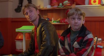 Movie still from “The Full Monty” (1997), directed by Peter Cattaneo – A man and a boy sitting next to each other in a room; Close Up shot, Over the shoulder angle