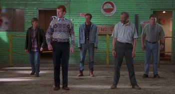 Movie still from “The Full Monty” (1997), directed by Peter Cattaneo – A group of people standing in a room; Wide shot, Low angle