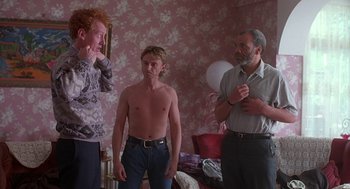 Movie still from “The Full Monty” (1997), directed by Peter Cattaneo – A group of people standing in a living room; Medium shot, Low angle