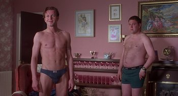 Movie still from “The Full Monty” (1997), directed by Peter Cattaneo – Two men in their underwear in front of a pink wall; Medium shot, Low angle