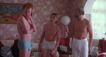 Movie still from “The Full Monty” (1997), directed by Peter Cattaneo – A group of people in their underwear in a room; Medium shot, Low angle