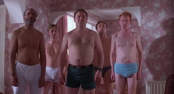 Movie still from “The Full Monty” (1997), directed by Peter Cattaneo – A group of men standing next to each other in their underwear; Medium shot, Low angle