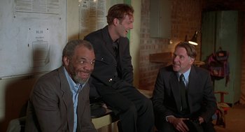 Movie still from “The Full Monty” (1997), directed by Peter Cattaneo – A group of men sitting next to each other in a room; Medium shot, Low angle