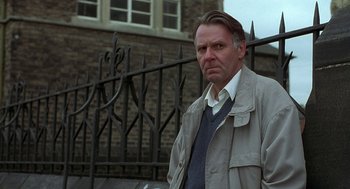 Movie still from “The Full Monty” (1997), directed by Peter Cattaneo – A man standing in front of an iron fence; Close Up shot, Low angle