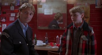 Movie still from “The Full Monty” (1997), directed by Peter Cattaneo – Two young men standing next to each other in front of a mirror; Medium shot, Over the shoulder angle