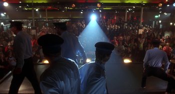 Movie still from “The Full Monty” (1997), directed by Peter Cattaneo – A group of men standing in front of an audience; Wide shot, Low angle