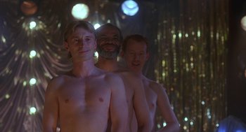 Movie still from “The Full Monty” (1997), directed by Peter Cattaneo – A group of naked men standing next to each other; Medium shot, Low angle