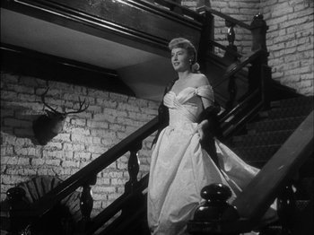 Movie still from “The Furies” (1950), directed by Anthony Mann – A black and white photo of a woman walking up stairs; Medium shot, Low angle