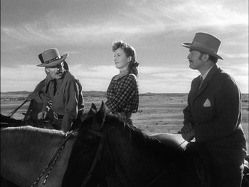 Movie still from “The Furies” (1950), directed by Anthony Mann – Two men and a woman on a horse in a field; Medium shot, Low angle