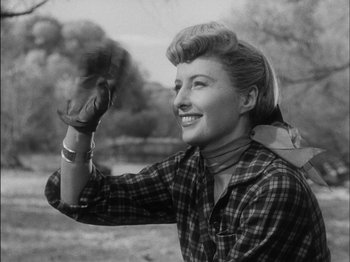 Movie still from “The Furies” (1950), directed by Anthony Mann – An old black and white photo of a woman waving; Medium shot, Low angle