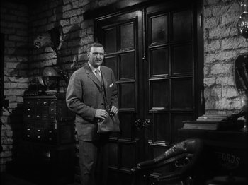 Movie still from “The Furies” (1950), directed by Anthony Mann – A man standing in front of a door way; Medium shot, Low angle