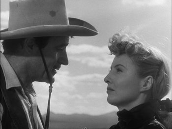 Movie still from “The Furies” (1950), directed by Anthony Mann – A man and a woman face to face in front of a sky background; Close Up shot, Low angle