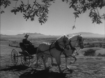 Movie still from “The Furies” (1950), directed by Anthony Mann – A man riding in a carriage pulled by two white horses; Wide shot, Low angle