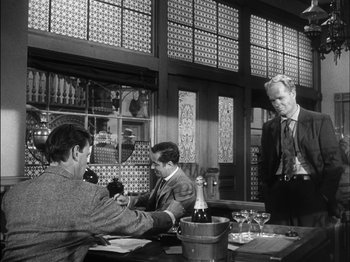 Movie still from “The Furies” (1950), directed by Anthony Mann – A group of men sitting at a table with wine glasses; Medium shot, Over the shoulder angle