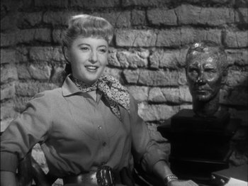 Movie still from “The Furies” (1950), directed by Anthony Mann – A woman standing next to a bust of a man; Close Up shot, Low angle