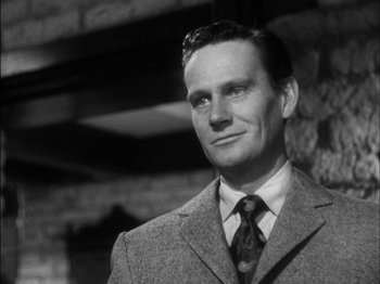 Movie still from “The Furies” (1950), directed by Anthony Mann – A man wearing a suit and tie in front of a brick wall; Close Up shot, Low angle