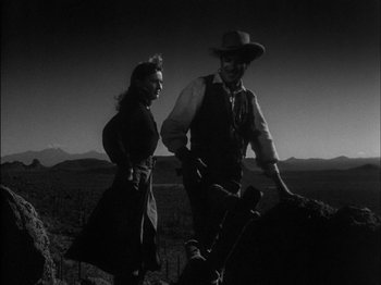 Movie still from “The Furies” (1950), directed by Anthony Mann – A man and a woman standing next to each other on top of a hill; Medium shot, Low angle