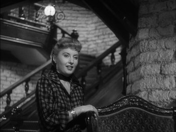 Movie still from “The Furies” (1950), directed by Anthony Mann – An old photo of a woman sitting on a chair in front of a staircase; Medium shot, Low angle