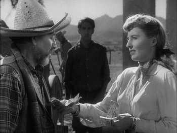 Movie still from “The Furies” (1950), directed by Anthony Mann – An old photo of a man and a woman exchanging a piece of paper; Medium shot, Over the shoulder angle