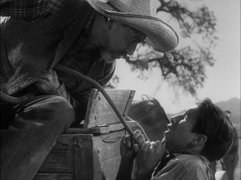 Movie still from “The Furies” (1950), directed by Anthony Mann – An old photo of a man and a young boy; Medium shot, Low angle