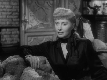 Movie still from “The Furies” (1950), directed by Anthony Mann – A black and white photo of a woman sitting on a couch; Close Up shot, Over the shoulder angle