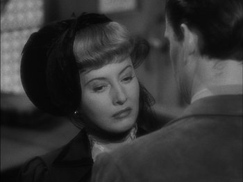 Movie still from “The Furies” (1950), directed by Anthony Mann – A woman in a black hat and a man in a brown jacket; Close Up shot, Over the shoulder angle