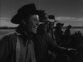 Movie still from “The Furies” (1950), directed by Anthony Mann – A black and white photo of a group of men wearing hats; Medium shot, Low angle
