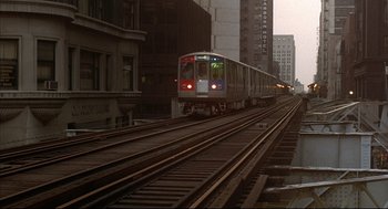 Movie still from “The Fury” (1978), directed by Brian De Palma – A train is going down the tracks in a city; Extreme Wide shot, High angle