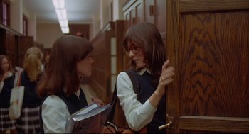 Movie still from “The Fury” (1978), directed by Brian De Palma – Two young women are talking to each other in a hallway; Medium shot, Over the shoulder angle