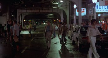 Movie still from “The Fury” (1978), directed by Brian De Palma – A group of people walking down a street at night; Wide shot, High angle