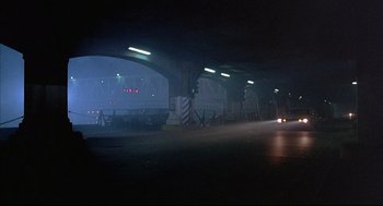Movie still from “The Fury” (1978), directed by Brian De Palma – A car driving down a street at night time; Extreme Wide shot, Low angle