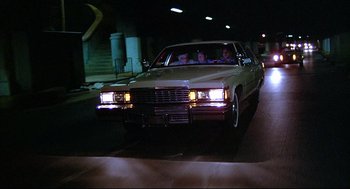 Movie still from “The Fury” (1978), directed by Brian De Palma – Two people in a car driving down a street; Wide shot, Low angle