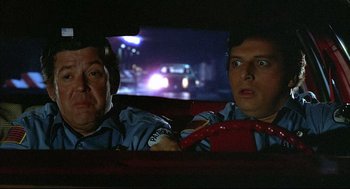 Movie still from “The Fury” (1978), directed by Brian De Palma – Two people in a car looking at a car on the road; Close Up shot, Over the shoulder angle