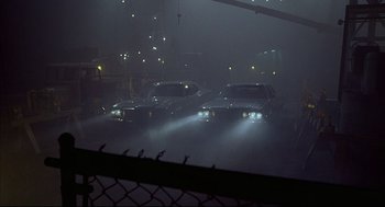 Movie still from “The Fury” (1978), directed by Brian De Palma – A group of cars parked in a parking lot at night; Wide shot, Low angle