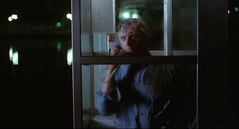 Movie still from “The Fury” (1978), directed by Brian De Palma – An older man talking on a cell phone through a window; Medium shot, Low angle