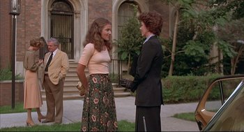 Movie still from “The Fury” (1978), directed by Brian De Palma – Two people standing on a sidewalk talking to each other; Wide shot, Over the shoulder angle