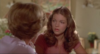 Movie still from “The Fury” (1978), directed by Brian De Palma – A young woman looking into a mirror while talking to another young woman; Close Up shot, Over the shoulder angle
