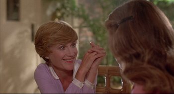 Movie still from “The Fury” (1978), directed by Brian De Palma – A woman sitting in front of another woman holding her hands; Close Up shot, Over the shoulder angle