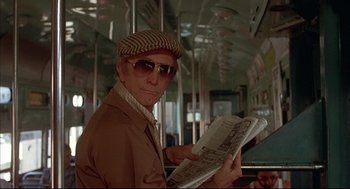 Movie still from “The Fury” (1978), directed by Brian De Palma – A man in a hat and sunglasses reading a newspaper; Medium shot, Low angle