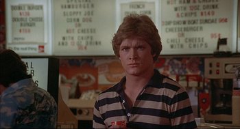 Movie still from “The Fury” (1978), directed by Brian De Palma – A man standing in front of a menu board in a restaurant; Close Up shot, Over the shoulder angle