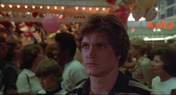 Movie still from “The Fury” (1978), directed by Brian De Palma – A person with a crowd in the background; Close Up shot, Low angle