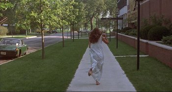 Movie still from “The Fury” (1978), directed by Brian De Palma – A woman running down a sidewalk in front of a building; Wide shot, High angle