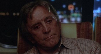 Movie still from “The Fury” (1978), directed by Brian De Palma – An older man sitting in front of a street light at night; Close Up shot, Low angle