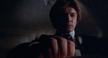Movie still from “The Fury” (1978), directed by Brian De Palma – A person wearing a suit and tie; Close Up shot, Low angle