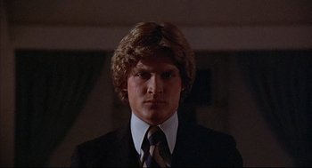 Movie still from “The Fury” (1978), directed by Brian De Palma – A man in a suit and tie in a dark room; Close Up shot, Low angle