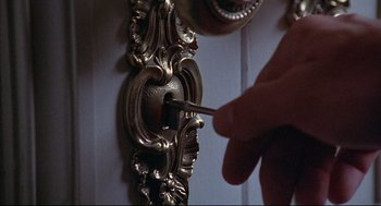 Movie still from “The Fury” (1978), directed by Brian De Palma – A hand is holding a key to a door knob; Extreme Close Up shot, High angle